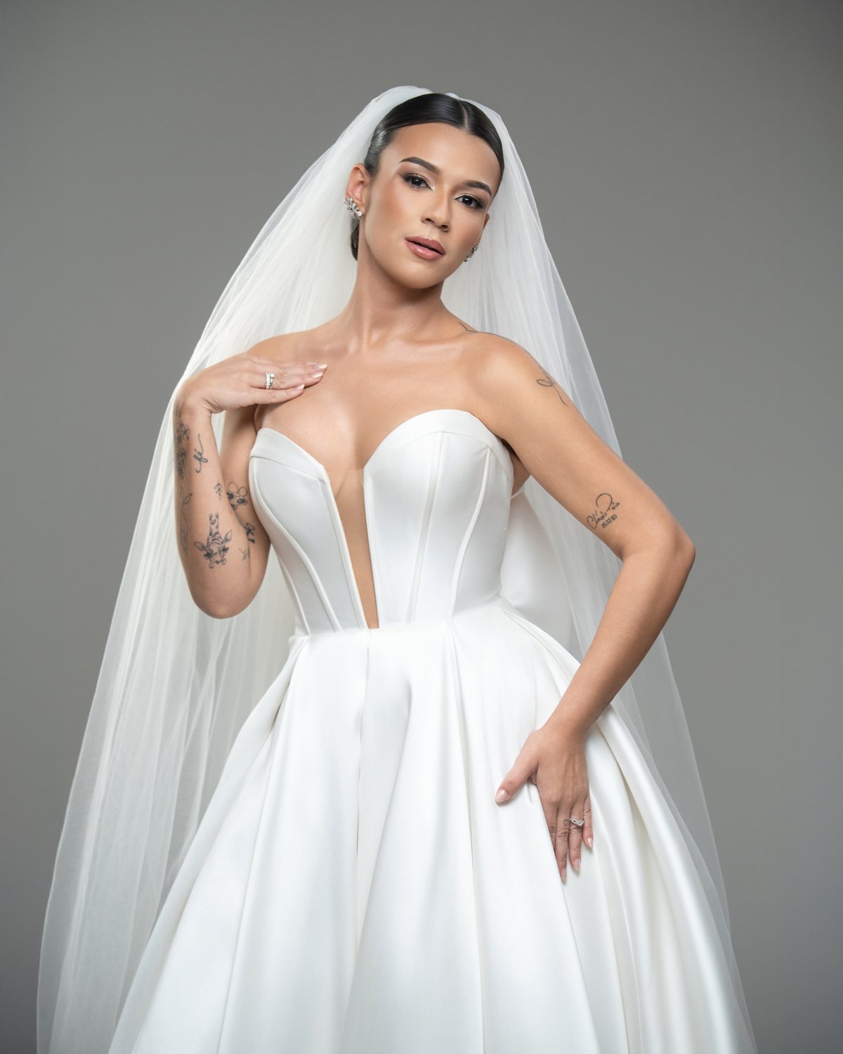 Noiva de vestido tomara que caia com saia volumosa, de corpo inteiro, em fundo cinza