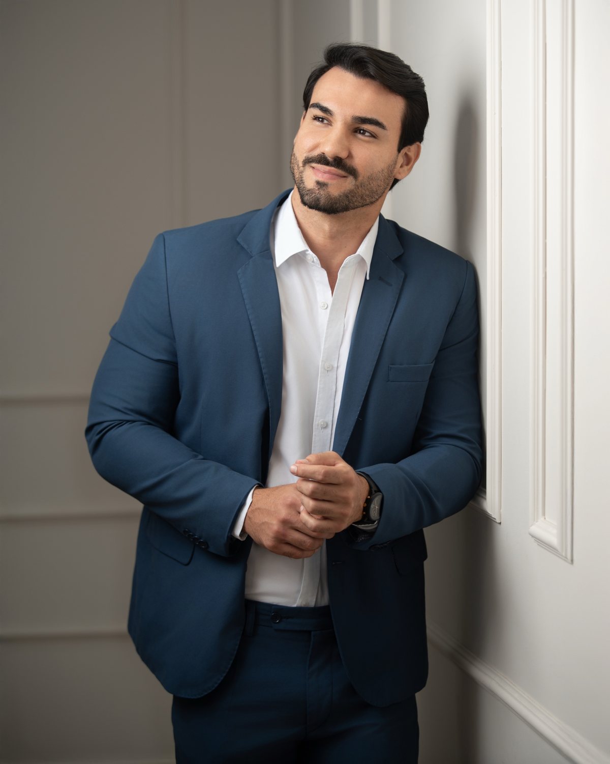 Retrato corporativo masculino: homem de terno azul encostado na parede de boiserie