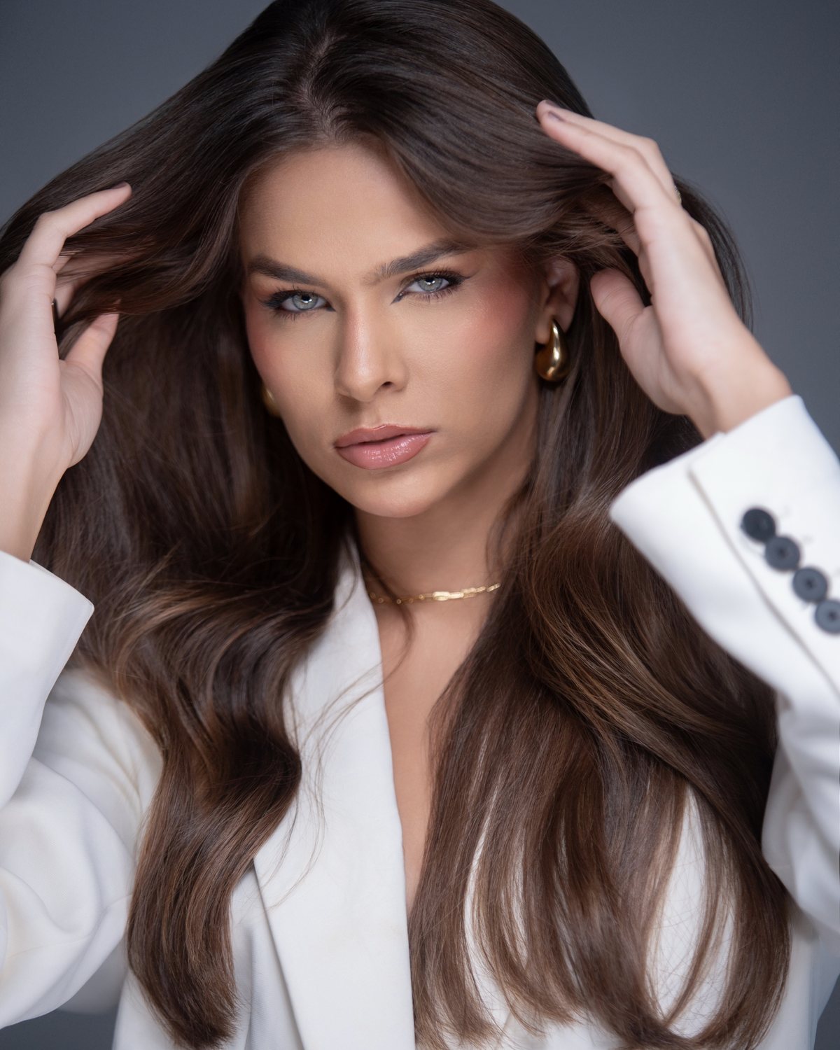 Retrato de beleza com cabelo castanho volumoso e blazer branco