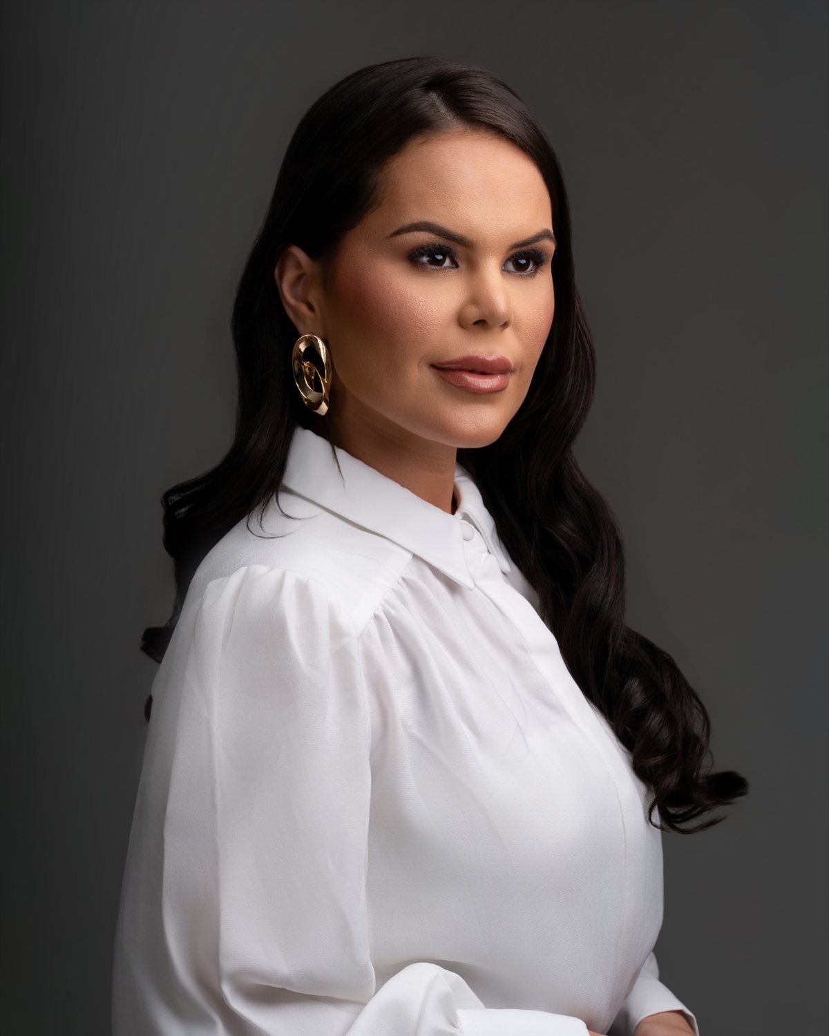Retrato profissional feminino com camisa branca e fundo cinza escuro